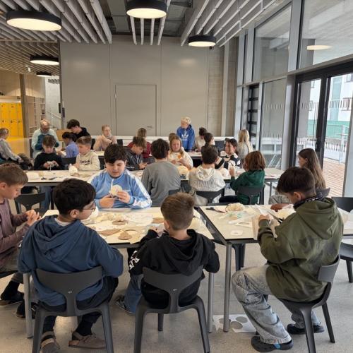 SchülerInnen sitzen an Tischen und basteln Schneemänner