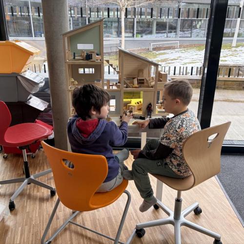 Kinder spielen mit Holz-Puppenhaus