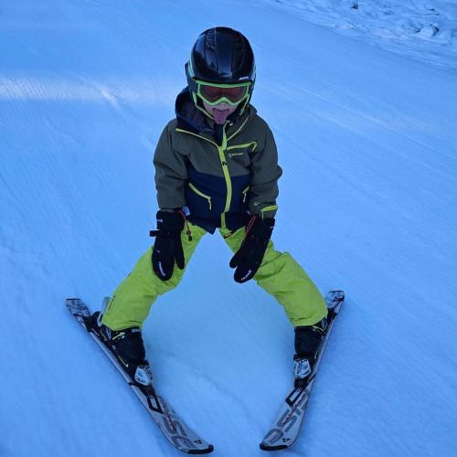 Kind auf Schiern zeigt Zunge