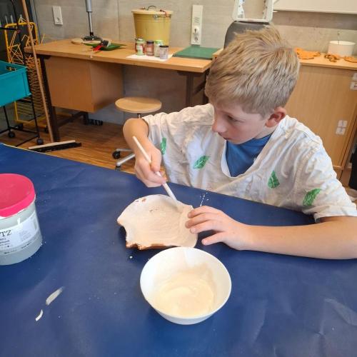 Kind beim Glasieren einer Tonschale