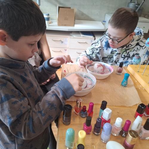 Kinder beim Färben von Plastikeiern