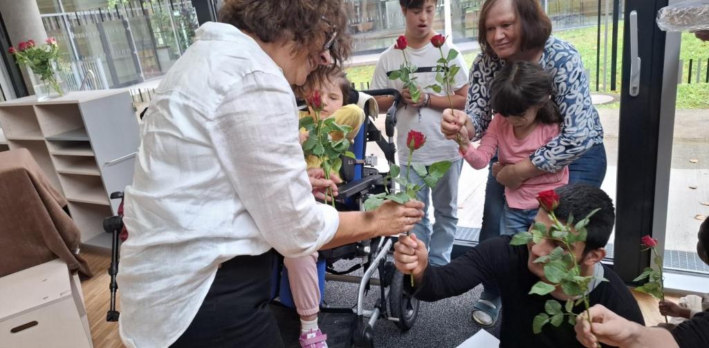 SchülerInnen überreichen der Direktorin Rosen